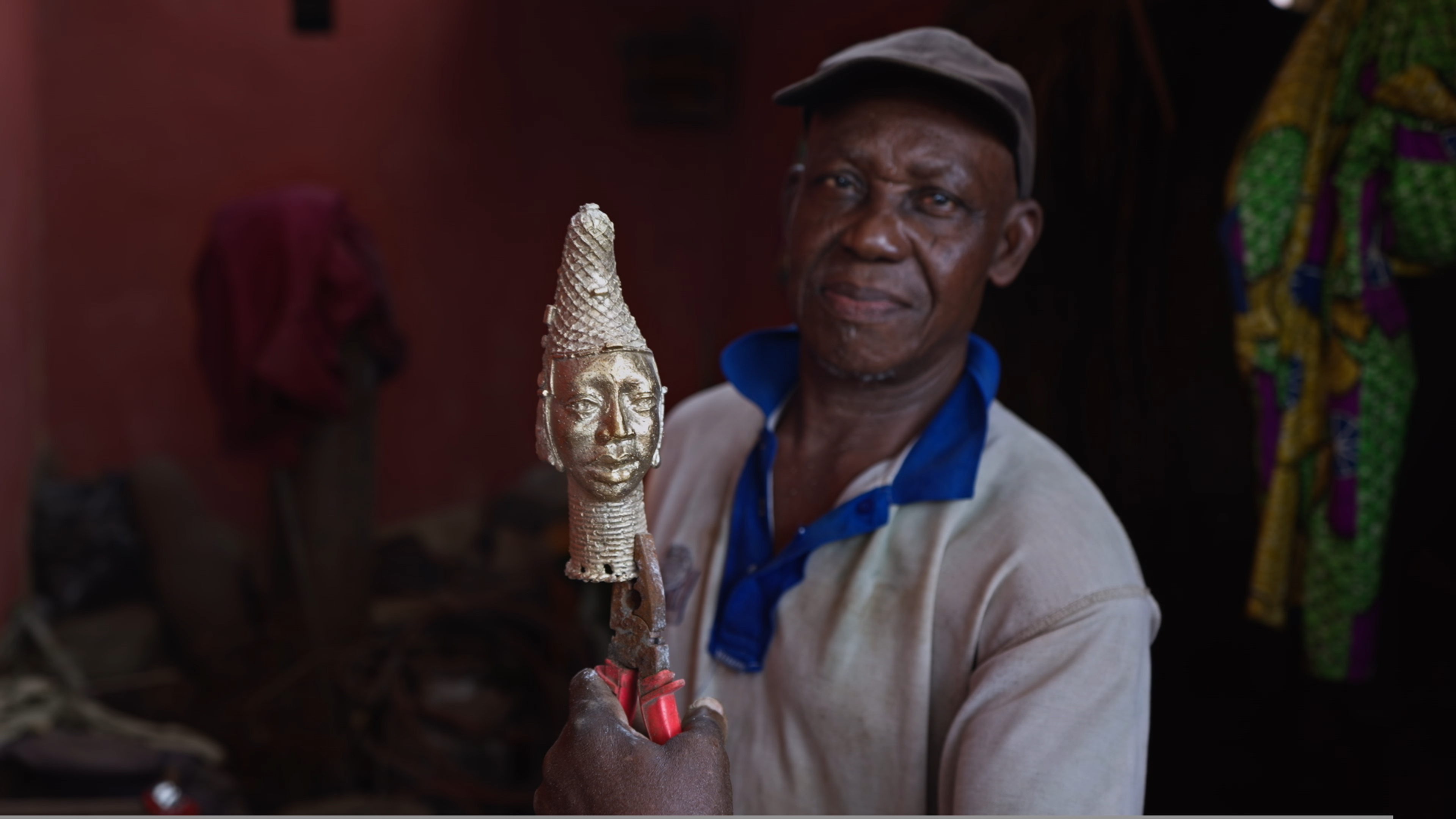 Bronze Caster holding his replica of (____)