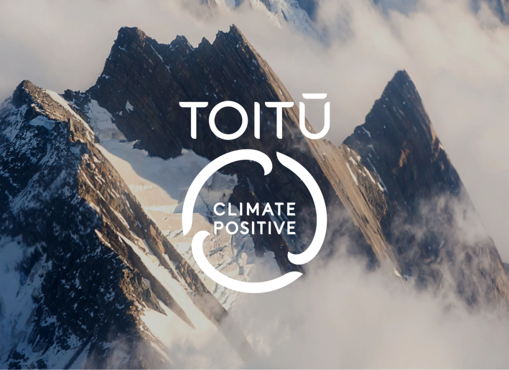 Toitu Carbon Positive Mark over mountain backdrop